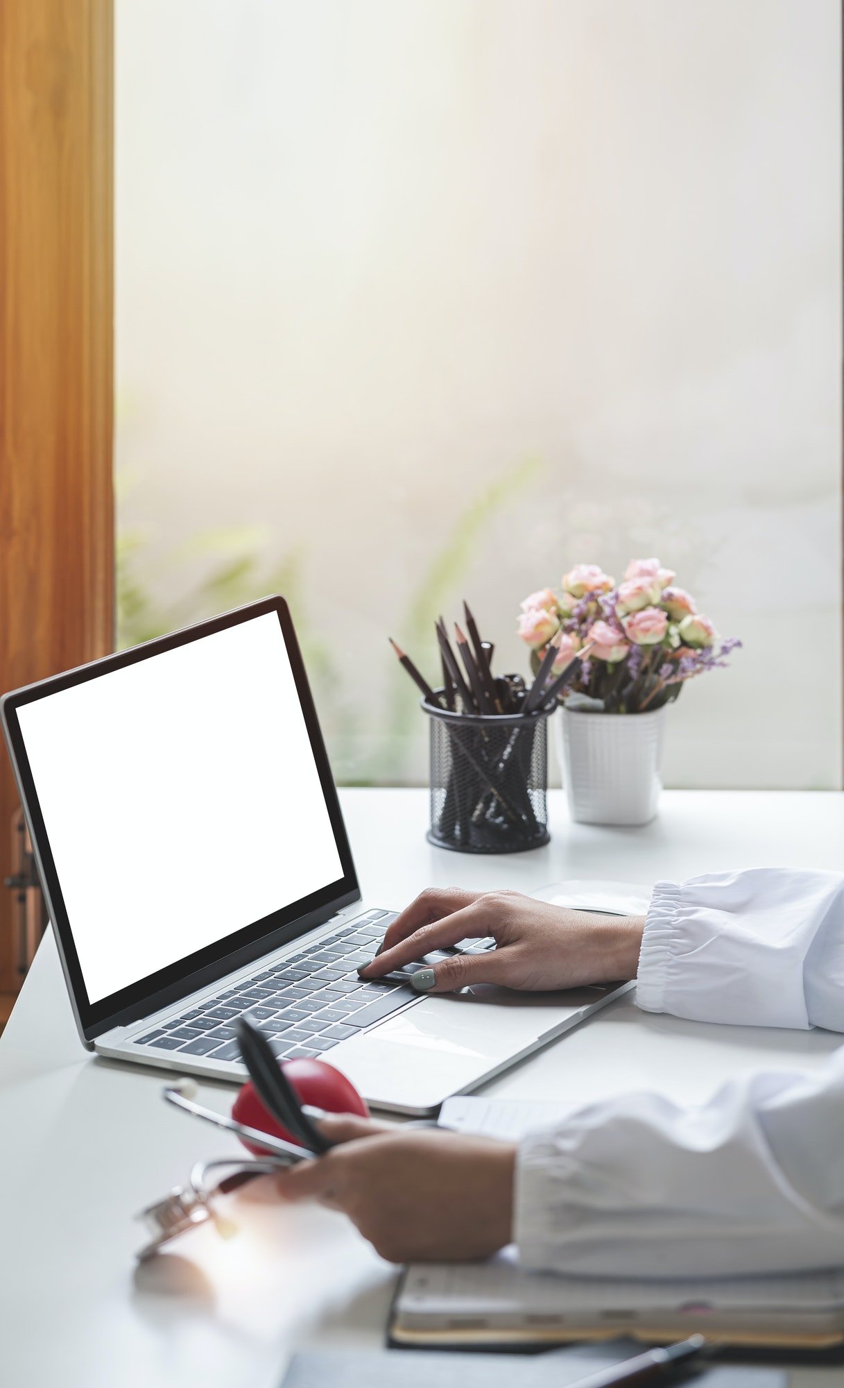 online medical consultation - doctor working on laptop computer in clinic office. copy space.