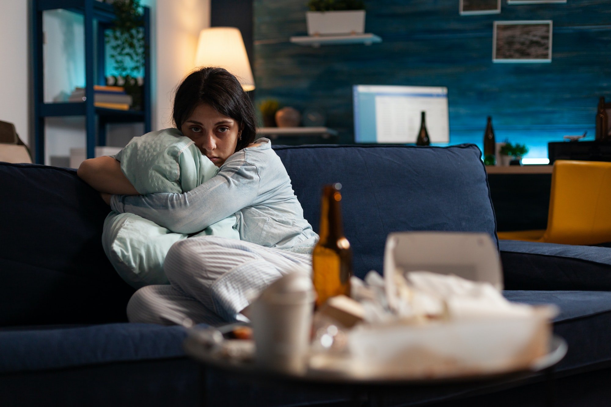 Traumatised, disappointed, frustrated, bipolar woman holding pillow looking lost in camera
