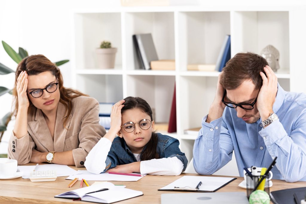 A stock photo of whole family holding their head looking confused understanding adhd.