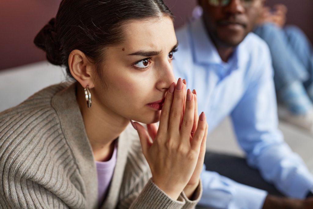 Emotional woman with hands in a nervous position.