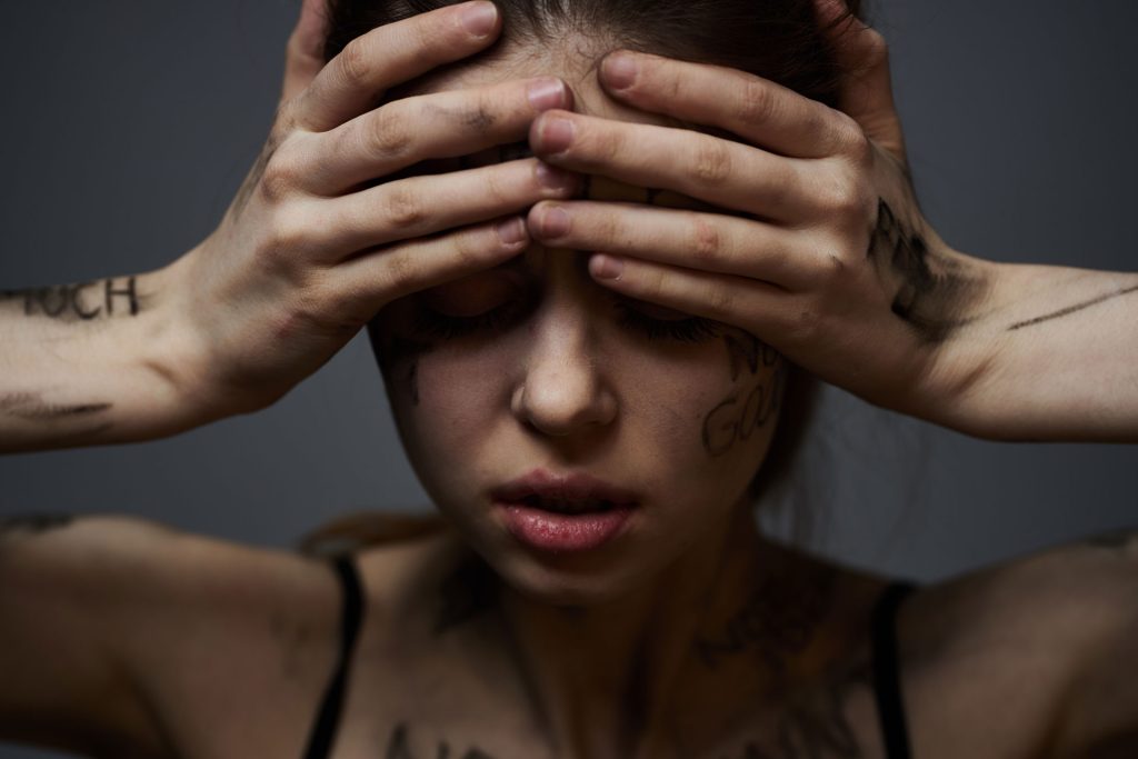 Frustrated woman with offensive inscription written all over her body.